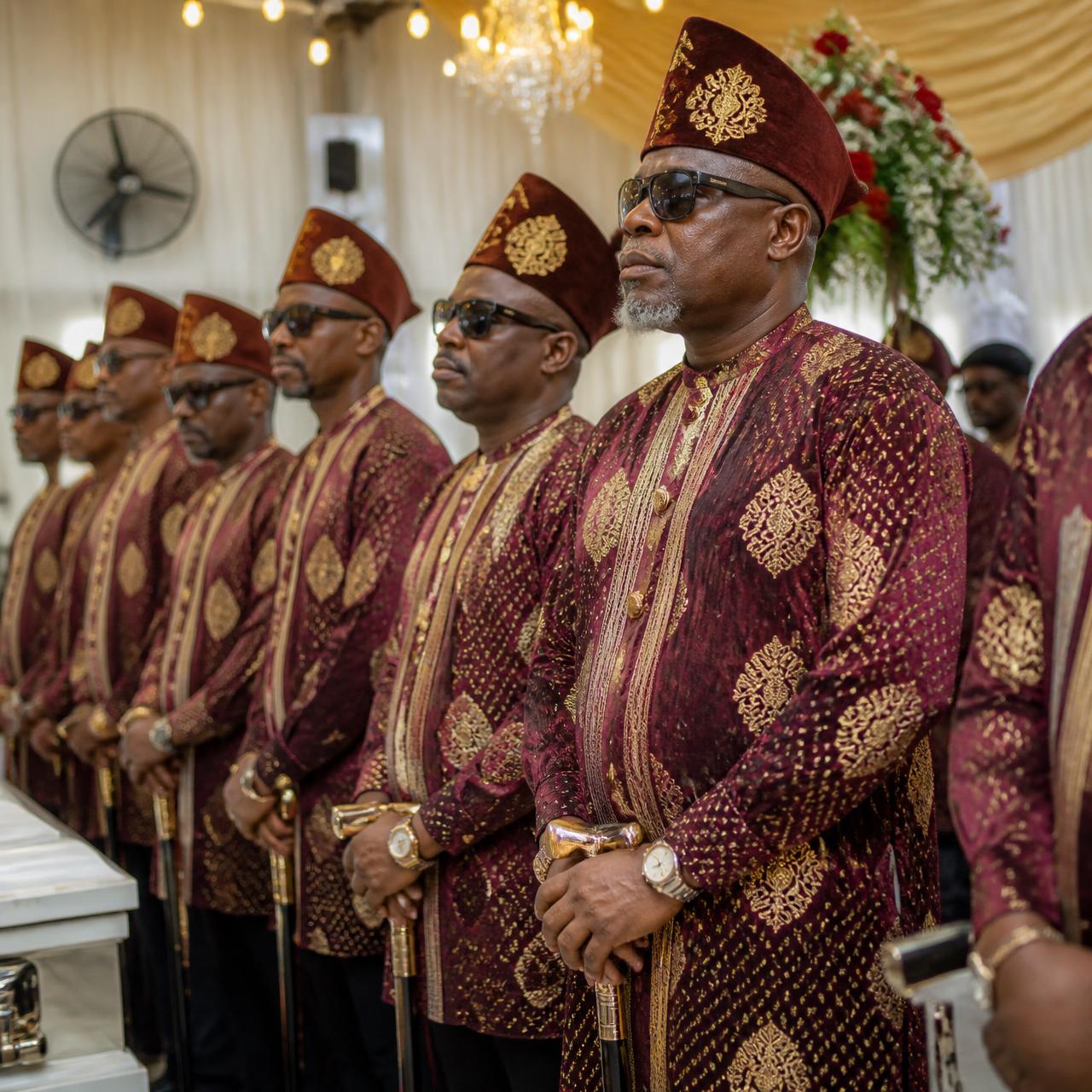 Professionally dressed Nigerian funeral attendants standing in a coordinated line at a ceremony